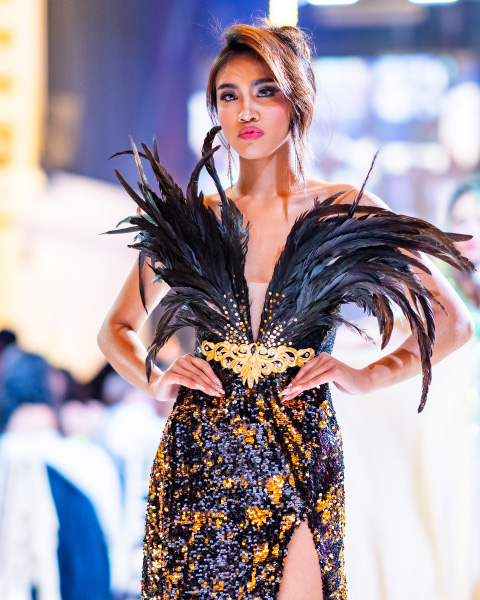 Contestant showcasing a dramatic feathered gown on the runway at Miss & Mr. Philippines UK.