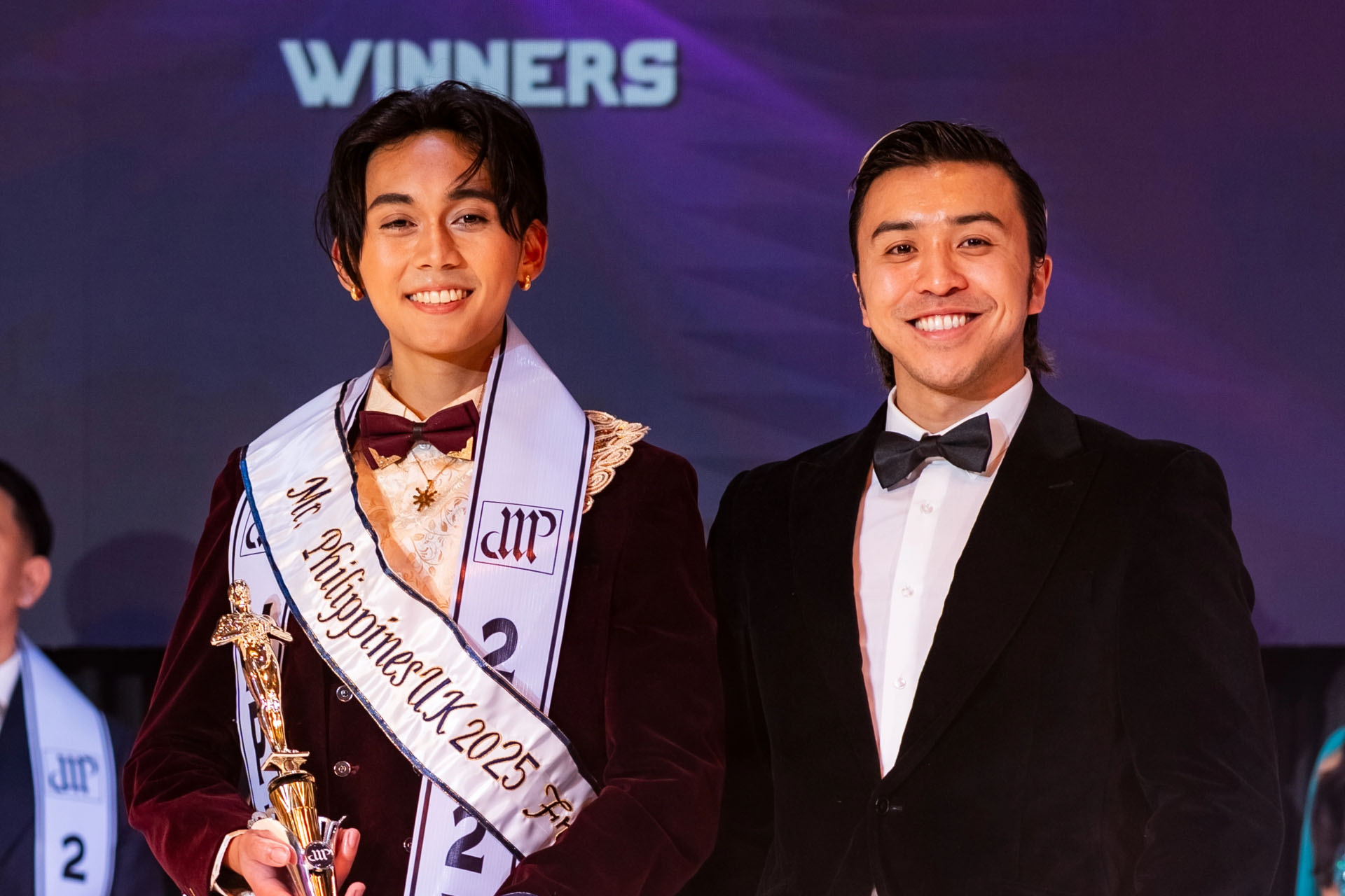Mr. Philippines UK 2025 winner posing with another event participant.