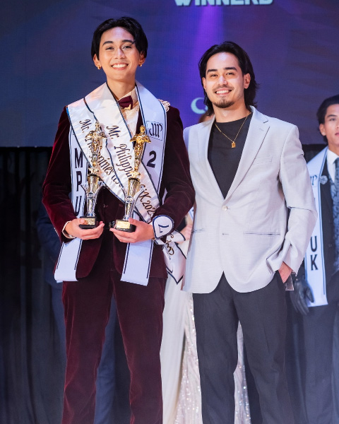 Mr. Philippines UK 2025 winner holding his trophies with another event participant.